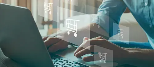 shopping cart graphics float overhands typing on a laptop
